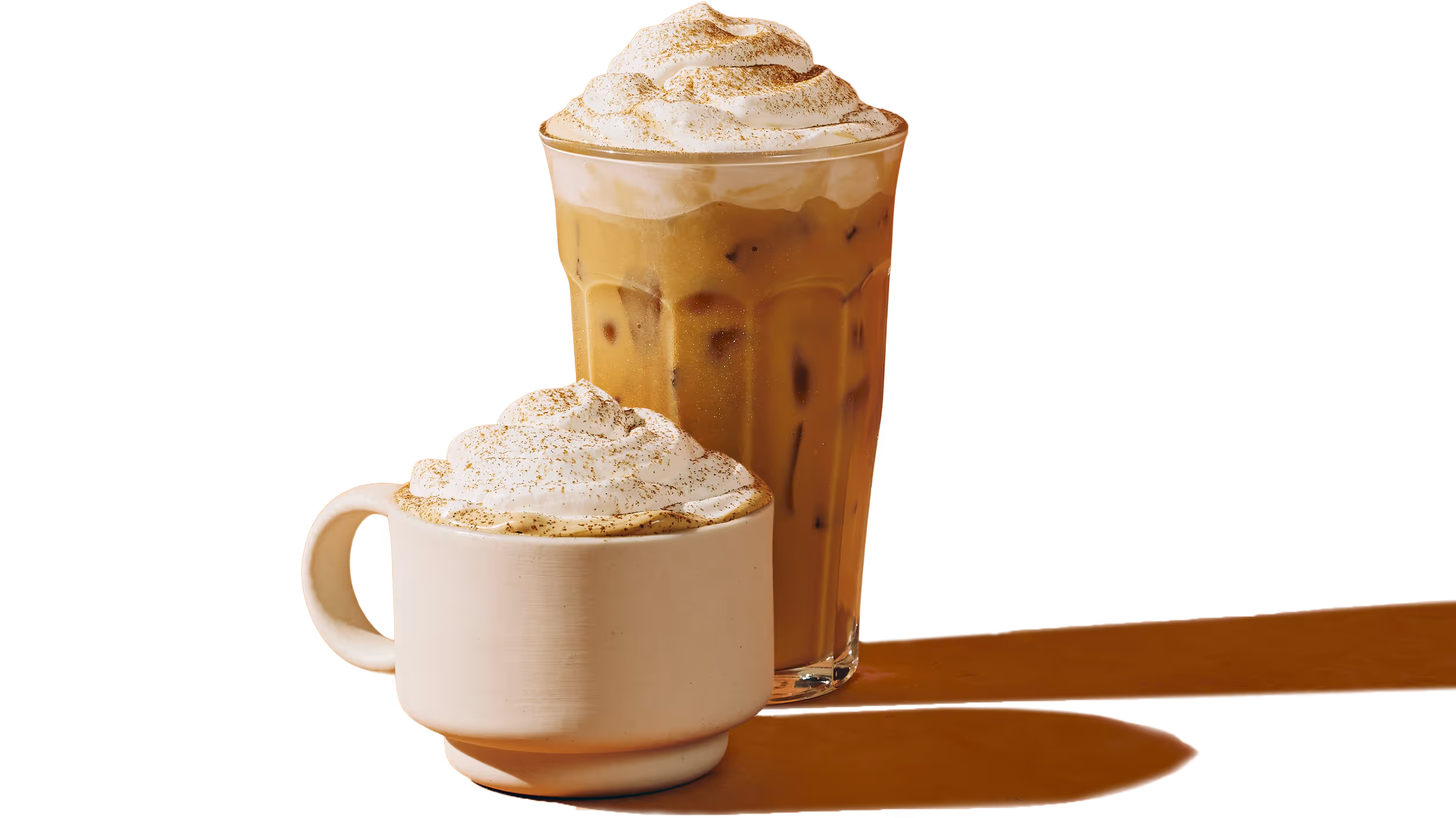 Two pumpkin spice lattes cut out as if sitting on a table or floor, one in a mug hot and the other in a cold iced glass